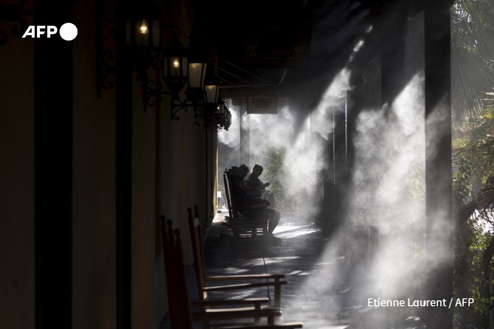 Visitors cool in the shade under misters on the porch of a hotel in Death Valley National Park