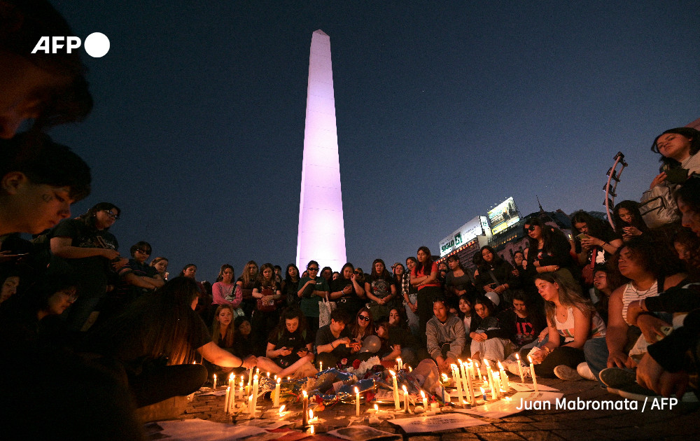 Fans light candles as they pay tribute to the late British singer Liam Payne at the Obelisco in Buenos Aires on October 17, 2024.