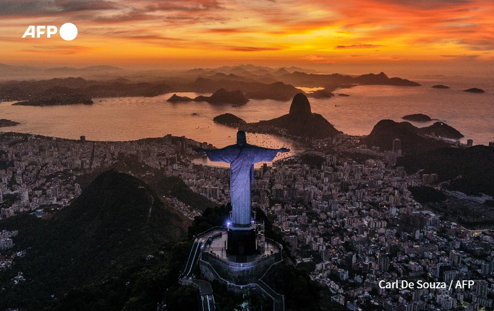 Sun rises in front of the Christ the Redeemer, Rio de Janeiro, Brazil