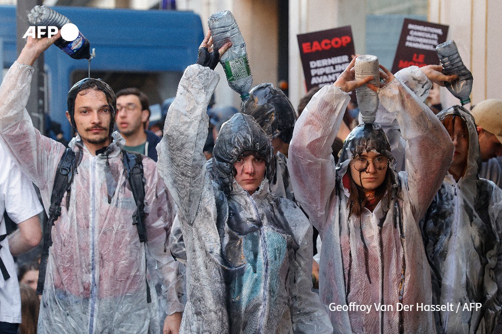 Climate protesters pour oil over them during a demonstration on the outskirts of the Paris venue for TotalEnergies Annual General Meeting