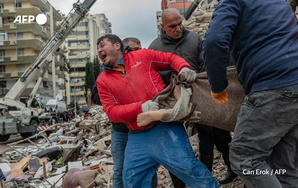 rescuers carrie a body found in the rubble after a 7.8-magnitude earthquake struck in Turkey.