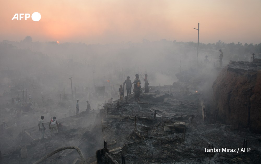 Rohingya refugees search fot their belongings after a fire broke out in Bangladesh.