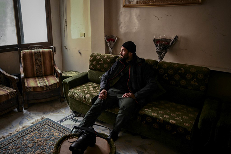 Sameer al-Doumy, photographe de l'AFP, assis sur le canapé de son salon à Douma, près de Damas. Aris Messinis