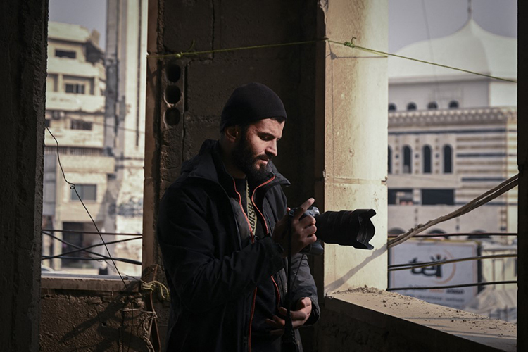 Syrian AFP photographer Sameer al-Doumy stands inside a damaged building in the city of Douma on December 22,