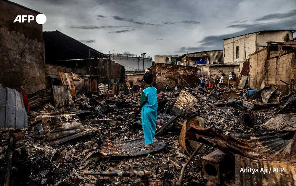 Boy in front of a burnt house in Jakarta, Indonesia.