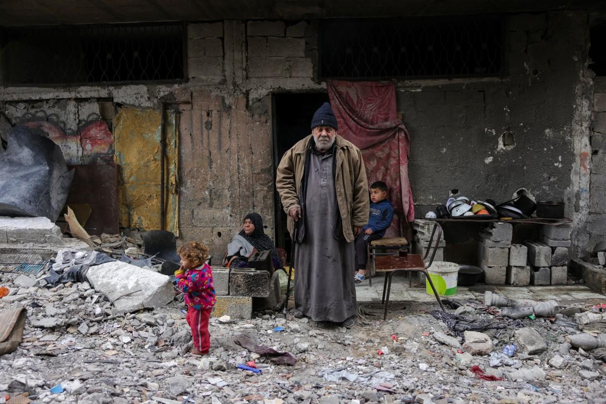 Talal Al-Assali, 64, poses in front of his destroyed home in Jabalia