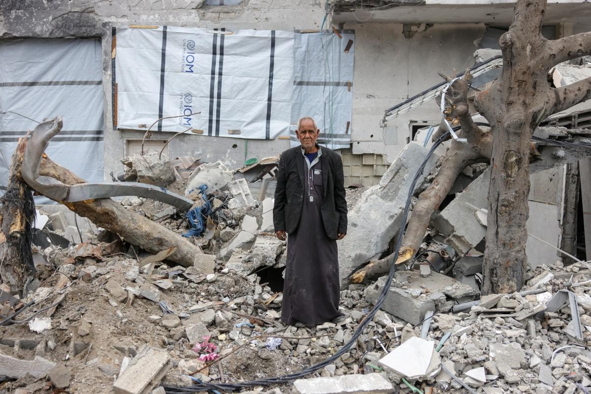 Ali Al-Qanoua, 73, poses in front of his destroyed home in Jabalia
