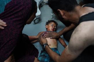  La mère d’un enfant palestinien tient son épaule alors qu'un homme essaie de le sauver  à l'hôpital des Martyrs d'Al-Aqsa dans le centre de la bande de Gaza. © Bashar Taled / AFP