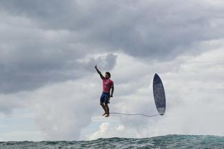 Photo emblématique du surfeur brésilien Gabriel Medina « en lévitation » au-dessus des vagues, prise pendant les JO 2024. © Jérôme Brouillet / AFP