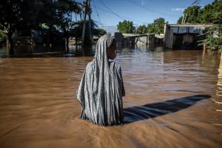 Une femme traversant les eaux en crue dans une zone industrielle à Garissa, au Kenya. © Luis Tato / AFP