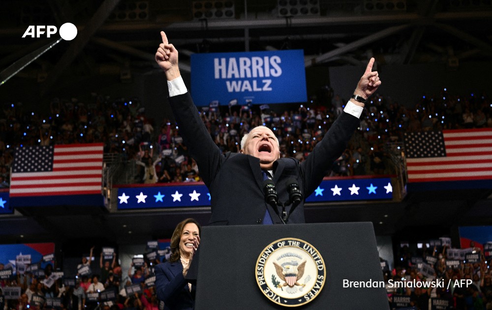 Democratic vice-presidential candidate Tim Walz raises his arms in the air 