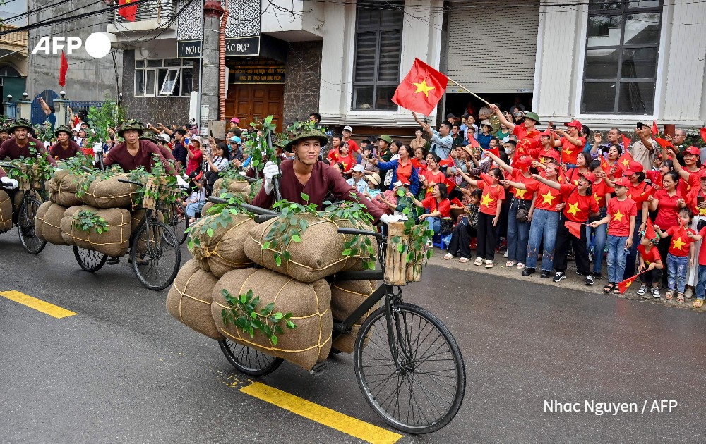 Performers walk with bicycles depicting the transportion of food and necessities